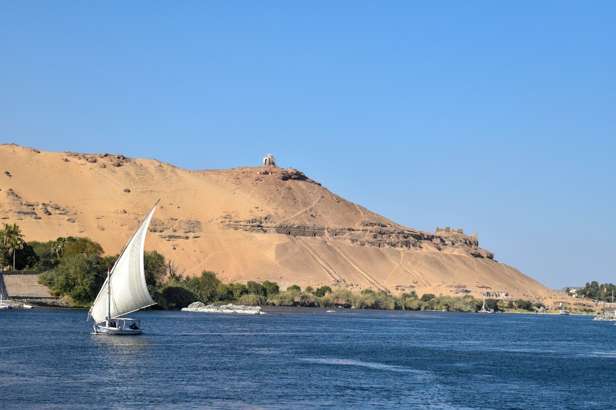 A felucca sailing on the Nile before the Tombs of the Nobles, Aswan